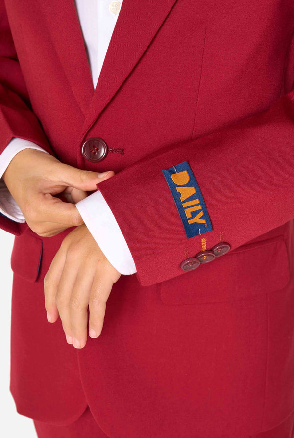 Kid wearing a stylish burgundy red suit with a white dress shirt, looking confidently. Perfect formal outfit for boys' special occasions, weddings, and parties. Sleeve close up.