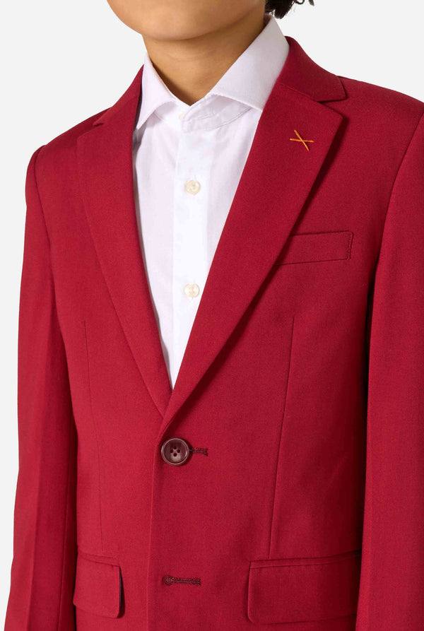 Kid wearing a stylish burgundy red suit with a white dress shirt, looking confidently. Perfect formal outfit for boys' special occasions, weddings, and parties. Chest close up.