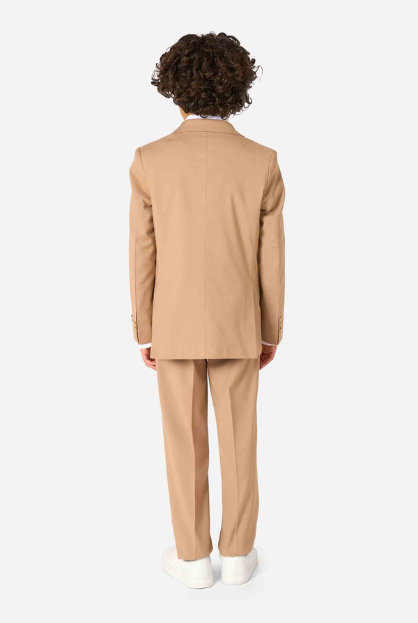 Kid wearing a stylish light brown/ beige suit with a white dress shirt, looking away from the camera. Perfect formal outfit for boys' special occasions, weddings, and parties. View from the back.