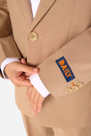 Kid wearing a stylish light brown/ beige suit with a white dress shirt, looking away from the camera. Perfect formal outfit for boys' special occasions, weddings, and parties. Focused on the sleeves.
