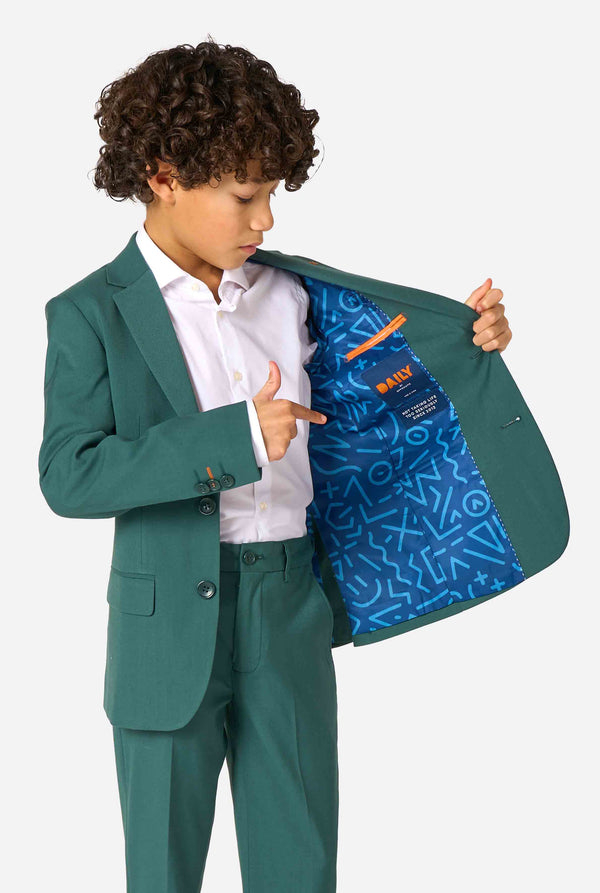 Kid wearing a stylish dark green suit with a white dress shirt, looking away from the camera. Perfect formal outfit for boys' special occasions, weddings, and parties. Holding one side of the jacket open.