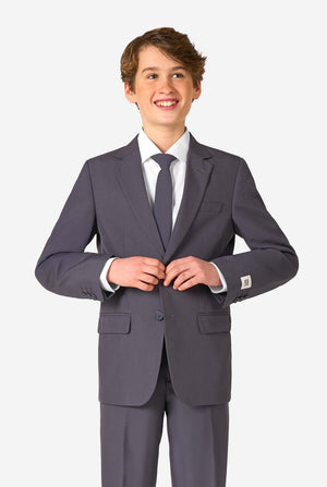Teen boy wearing a stylish charcoal colored grey suit with a white dress shirt, smiling confidently. Perfect formal outfit for boys' special occasions, weddings, and parties.