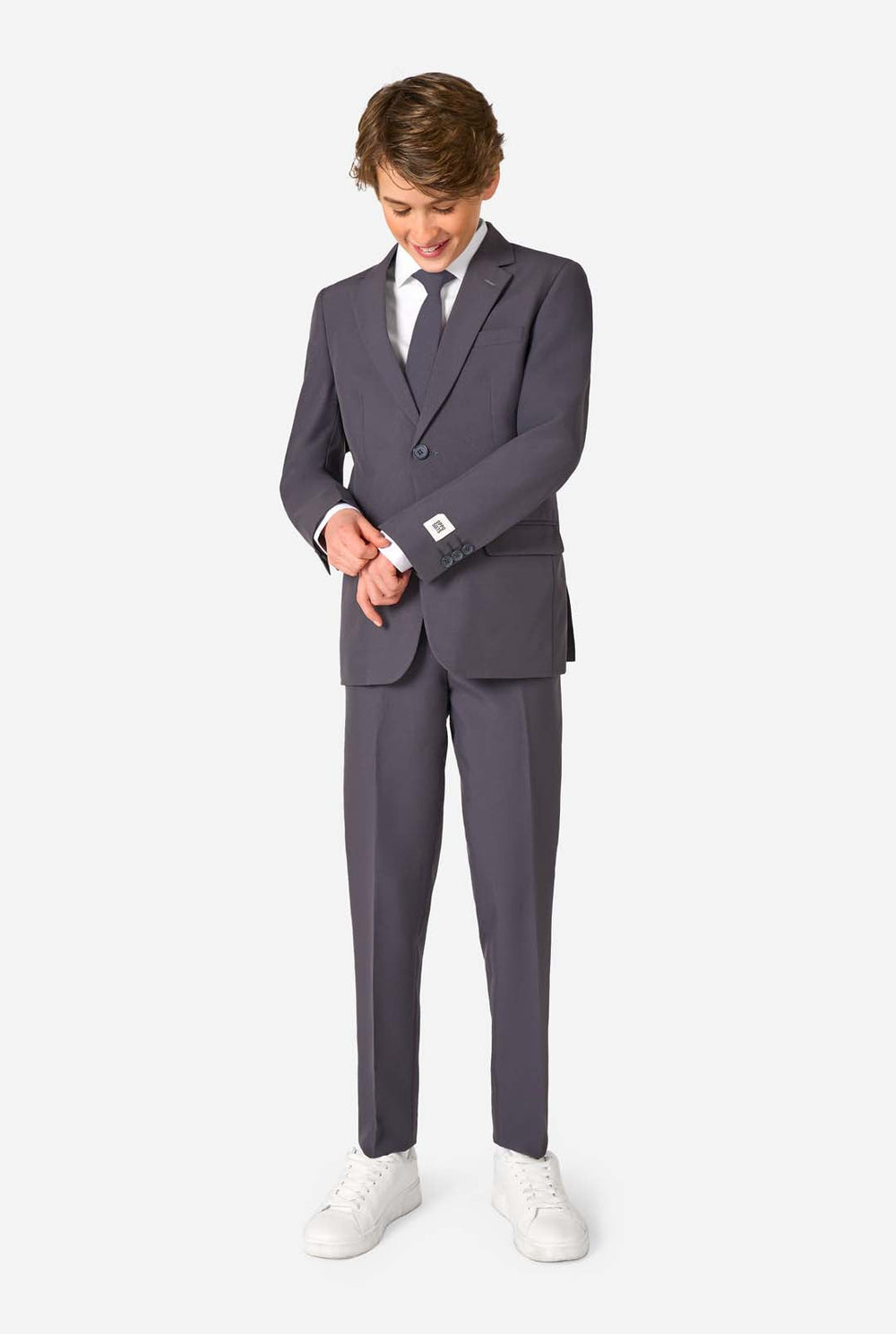 Teen boy wearing a stylish charcoal colored grey suit with a white dress shirt, smiling confidently. Perfect formal outfit for boys' special occasions, weddings, and parties.