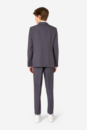 Teen boy wearing a stylish charcoal colored grey suit with a white dress shirt, smiling confidently. Perfect formal outfit for boys' special occasions, weddings, and parties. View from the back.