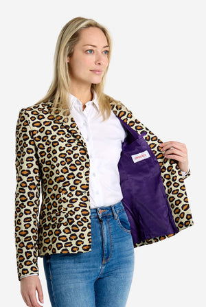Woman wearing a leopard print jacket with a purple lining, standing against a white background
