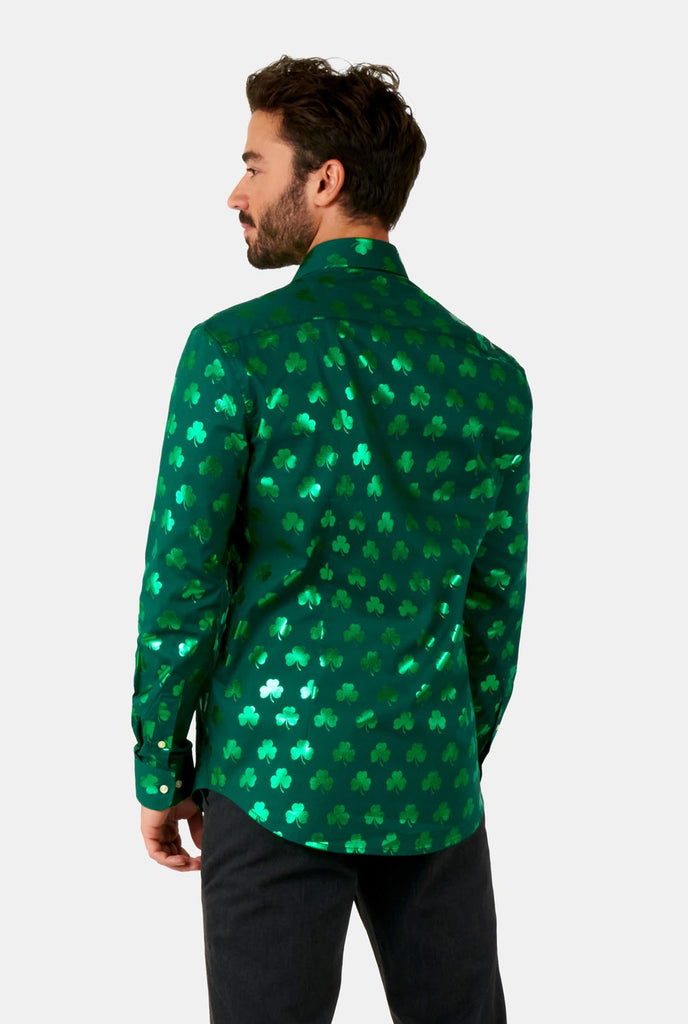 Man wearing Green St Patrick's Day shirt with green shiny clovers, view from the back